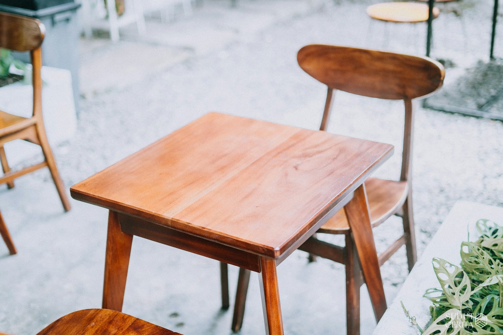 Gartentisch auf gepflasterter Terrasse mit sichtbaren Fugen