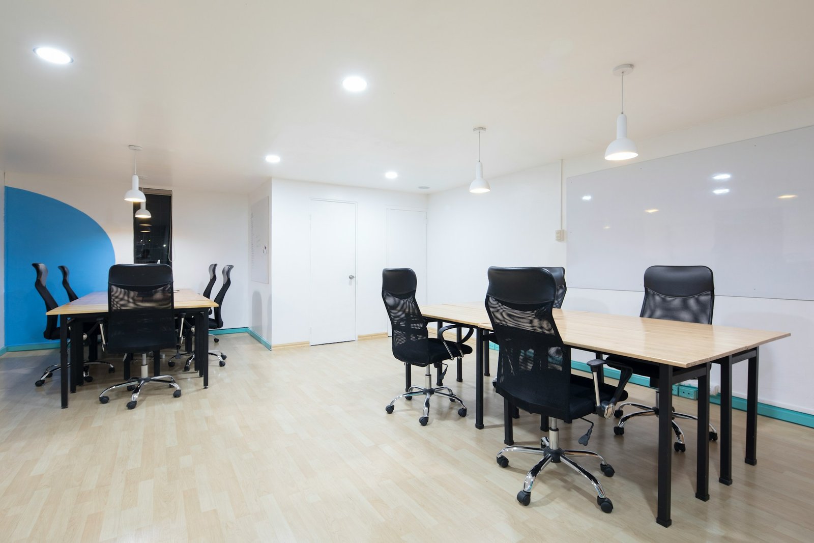 Schreibtisch mit Laptop auf glattem Boden, eine Ecke leicht angehoben