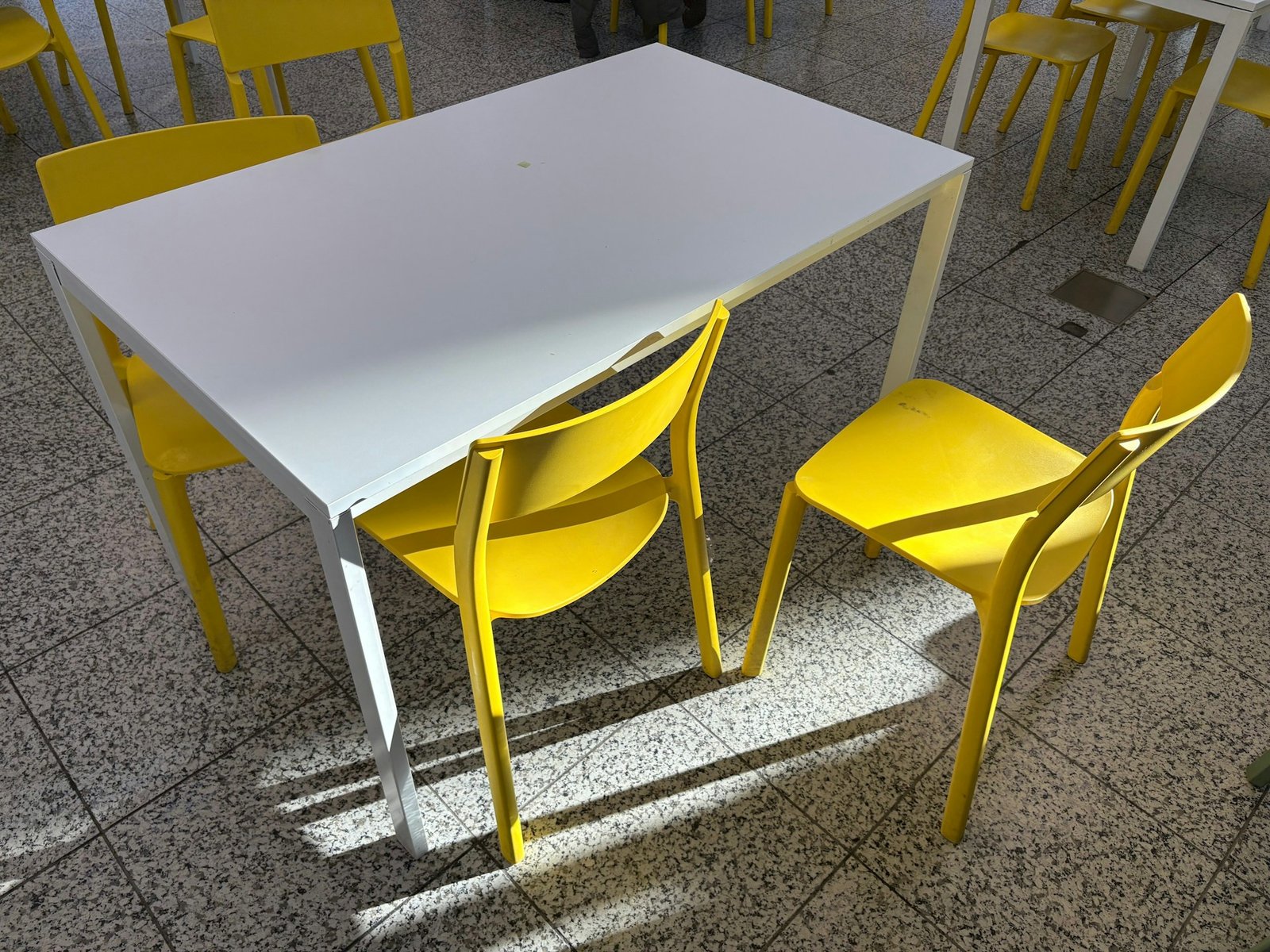 Holztisch auf gefliestem Boden mit sichtbaren Fugen